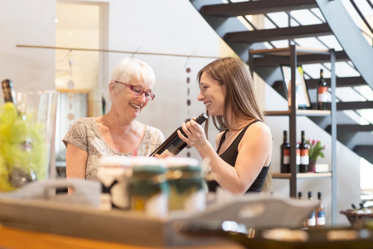 Winery employee discussing vintage tasting notes with customer