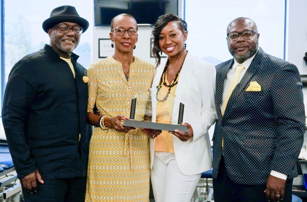 A group of people standing next to each other holding a trophy.