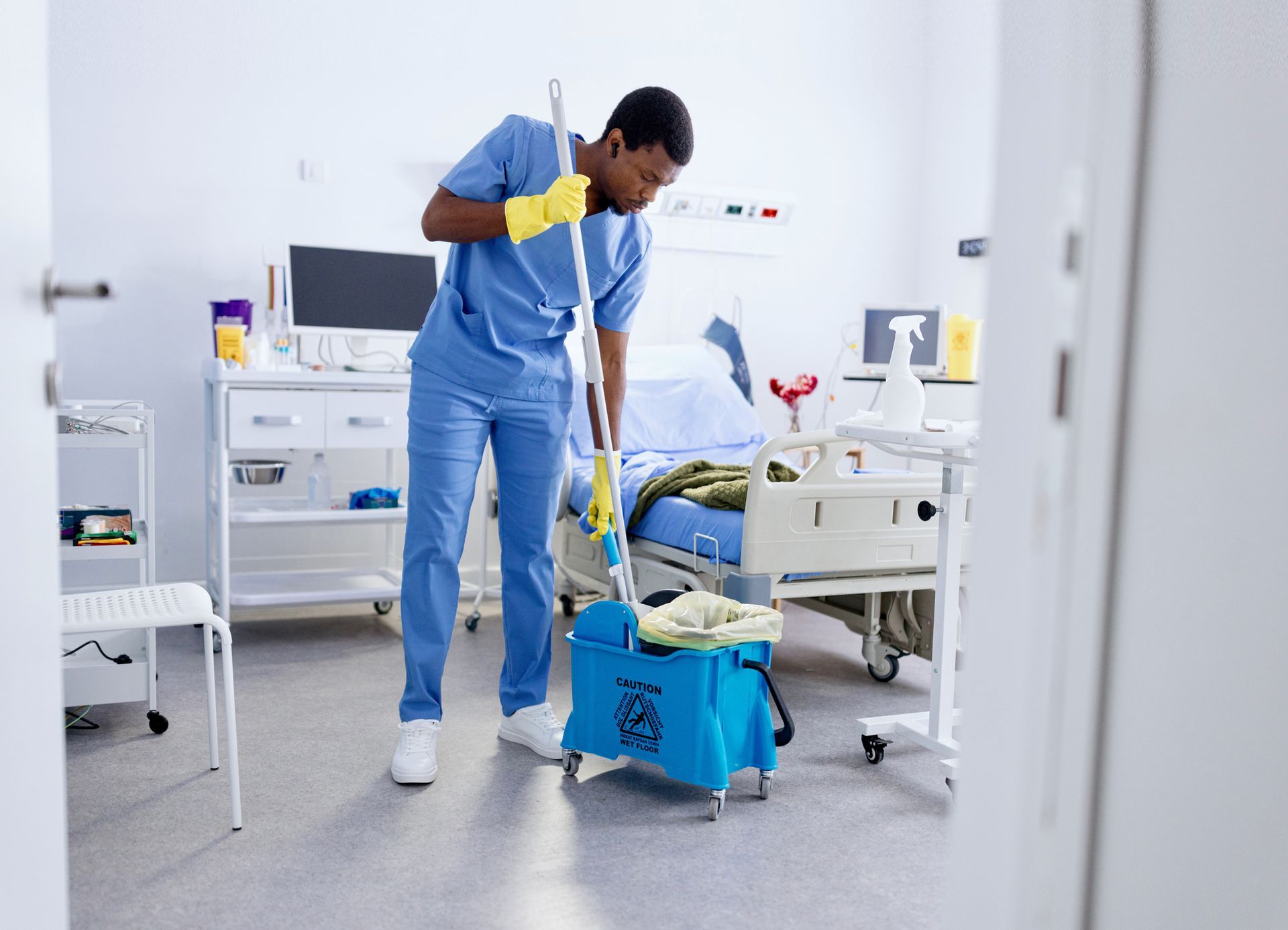 A worker is mopping the floor at a medical clinic. A worker is mopping the floor at a medical clinic.