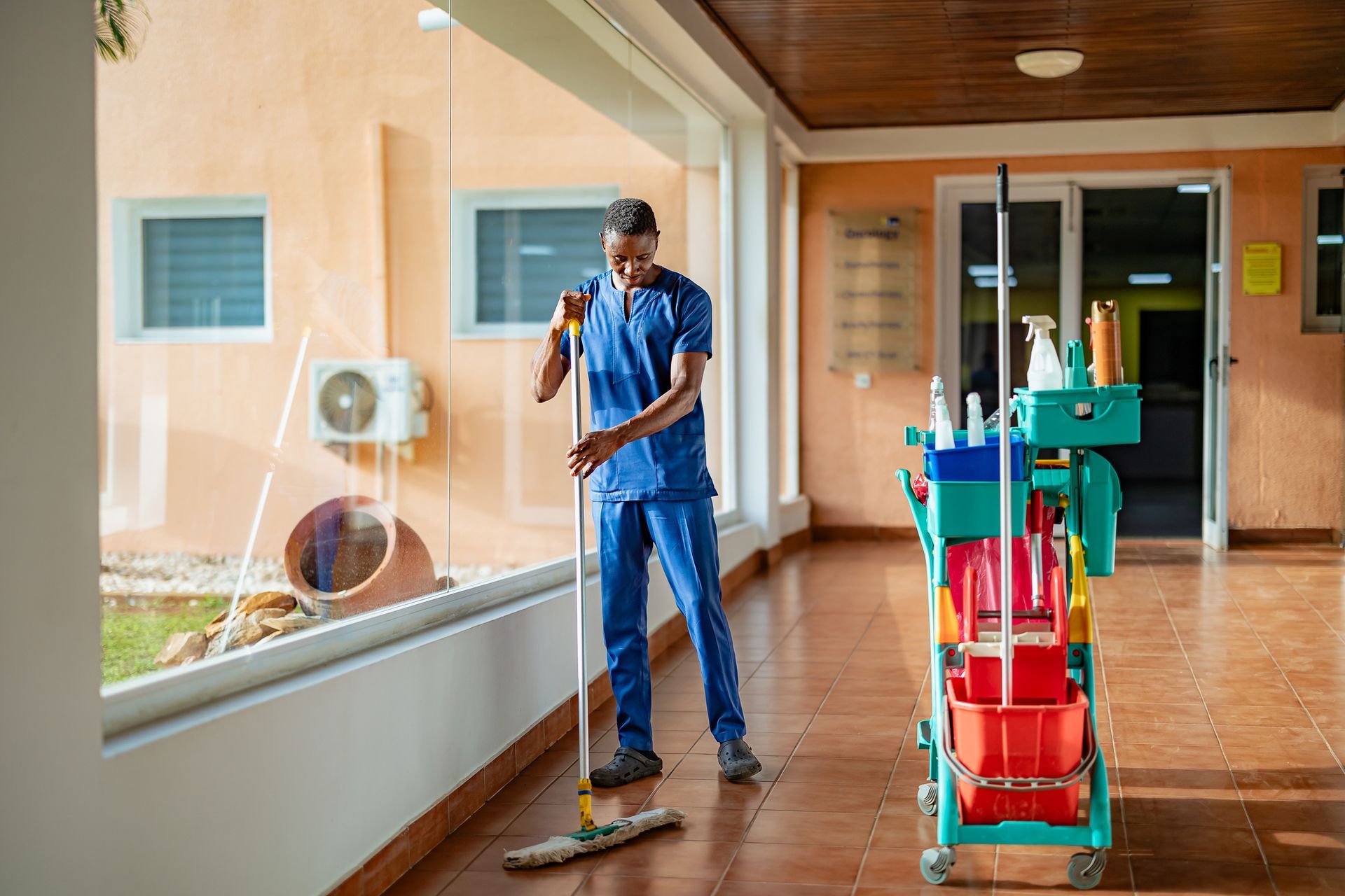 Male porter cleaning floor at an office building.