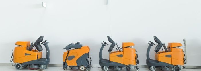 Industrial scrubber cleaning oil and fuel residue from a large aerospace hangar floor in Atlanta, GA