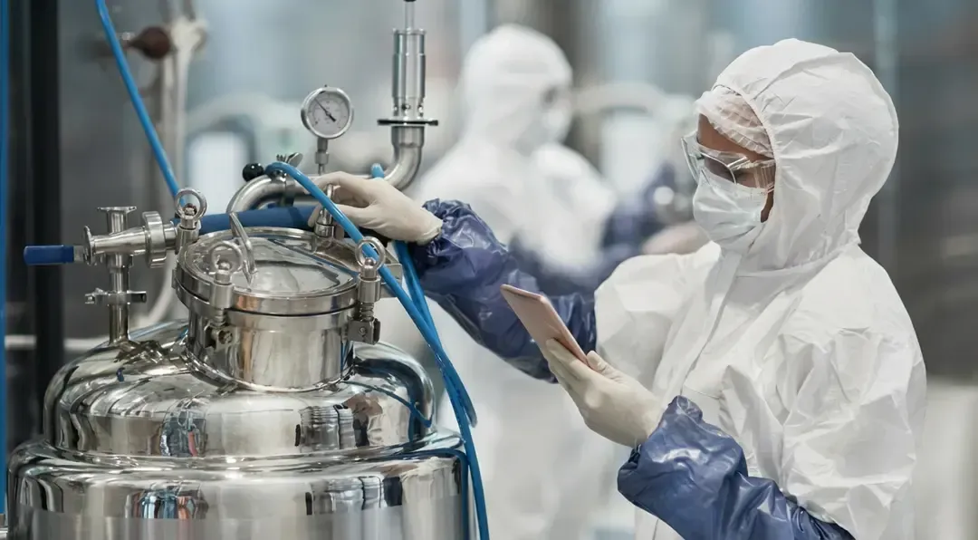 Researcher in Clean Suit Working with Equipment