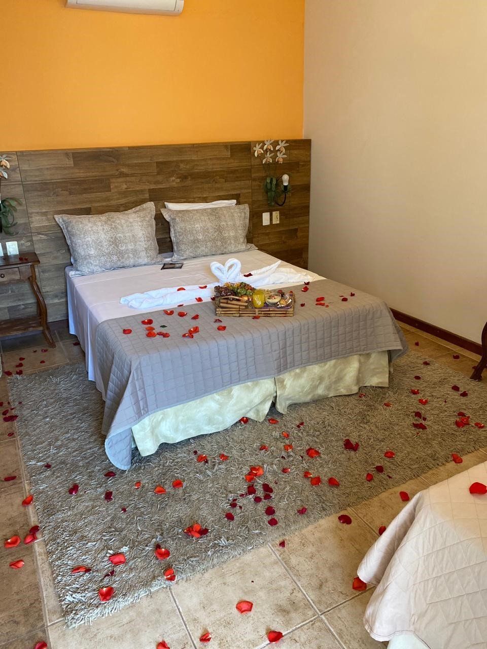 Um quarto com uma cama e pétalas no chão