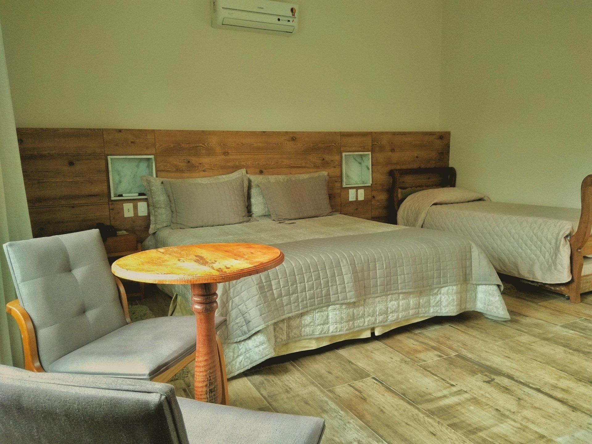 Um quarto de hotel com duas camas, uma mesa e cadeiras.