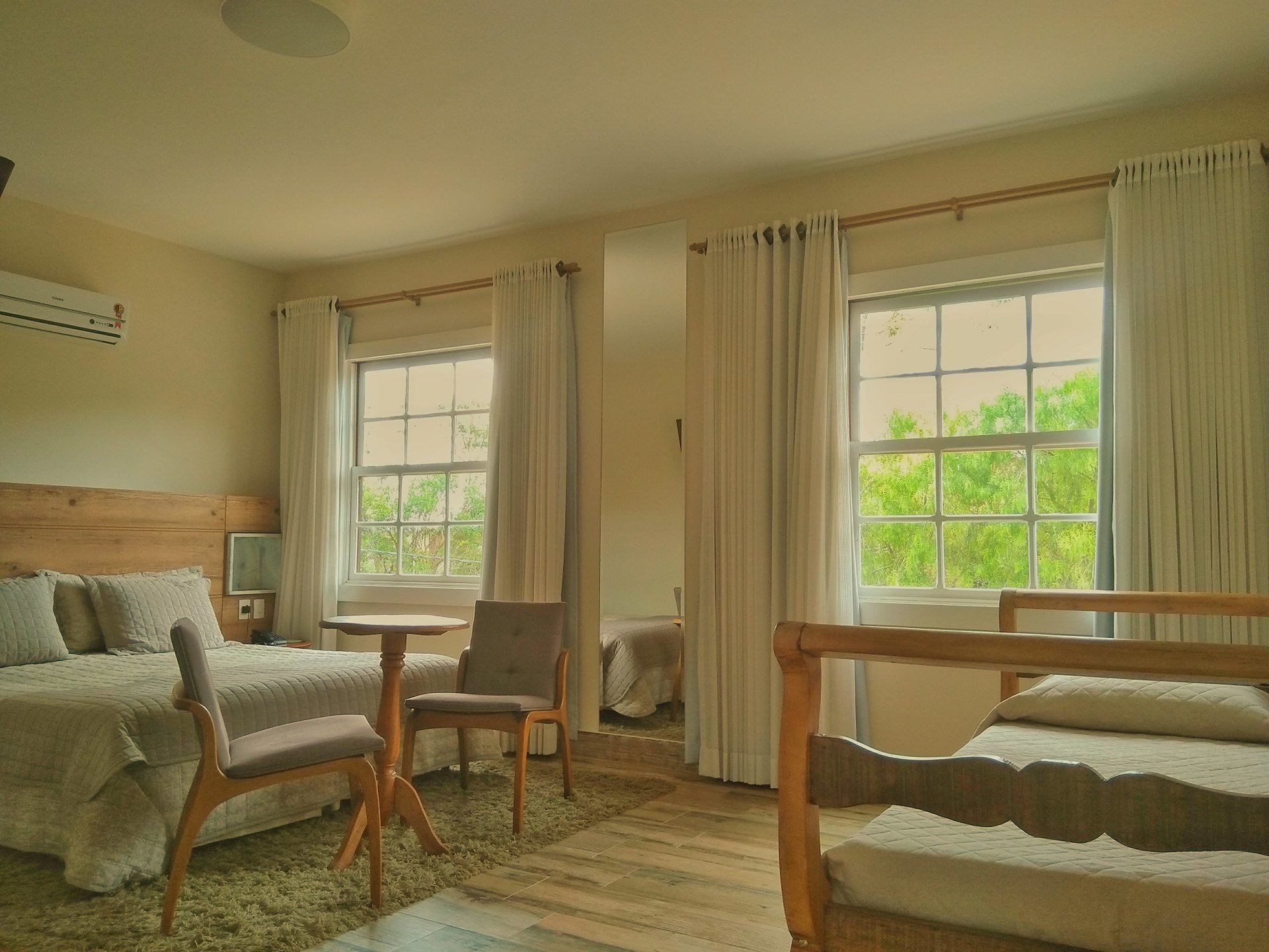 Um quarto de hotel com duas camas, uma mesa e cadeiras.