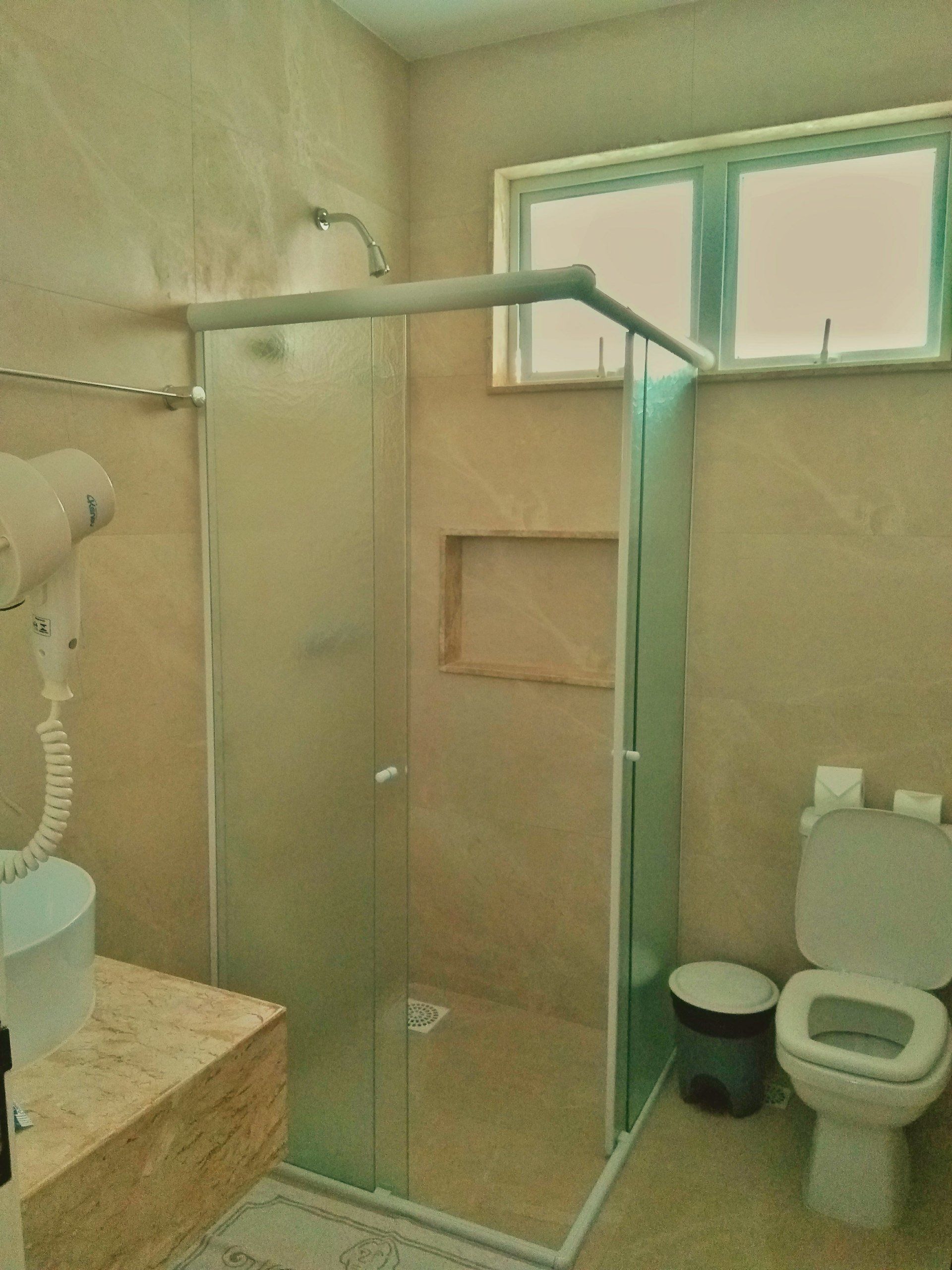 Um banheiro com vaso sanitário e chuveiro