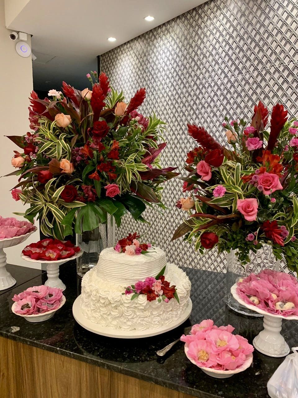 Uma mesa com um bolo e flores.