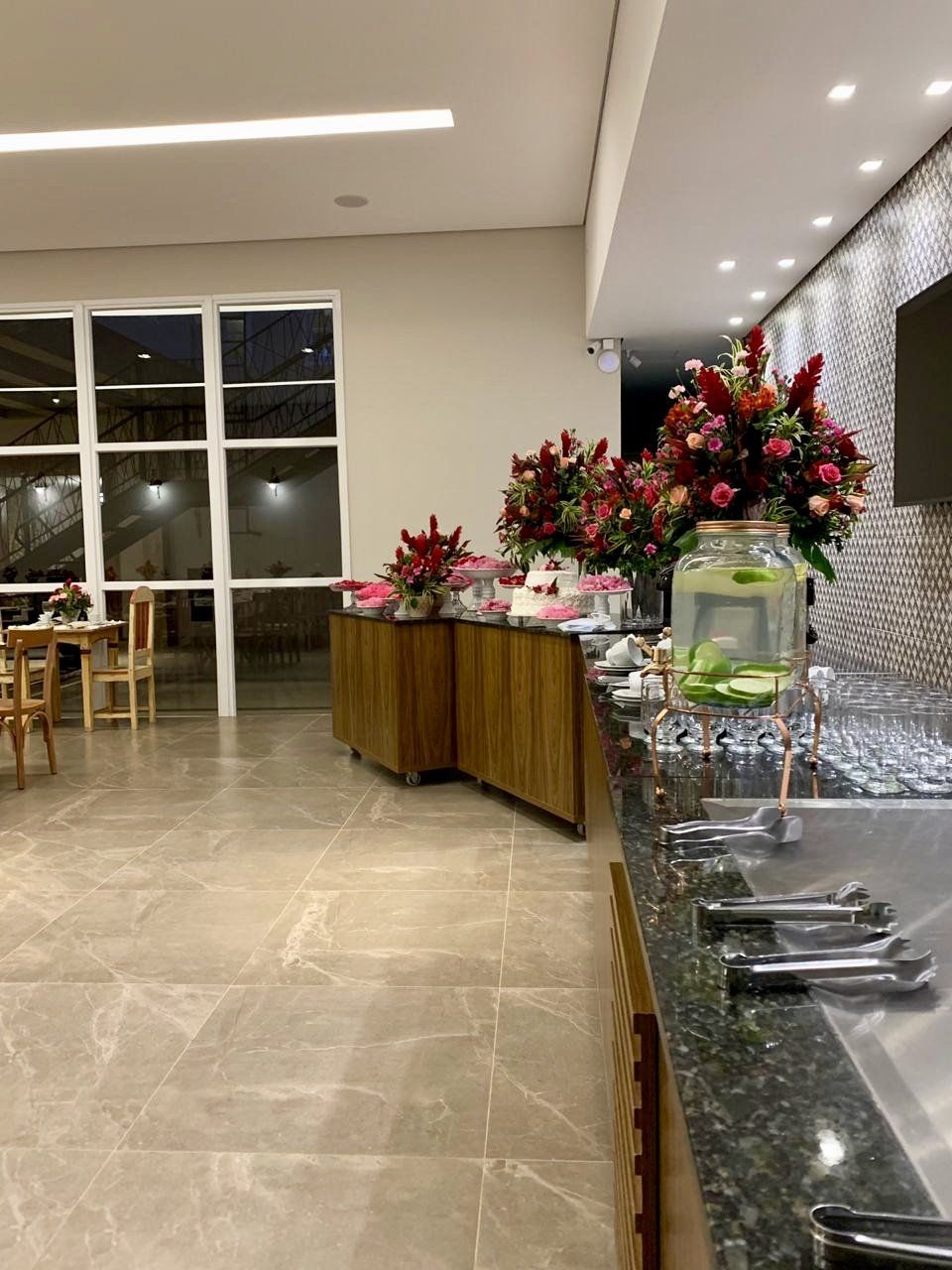 Um restaurante com bufê e flores no balcão.