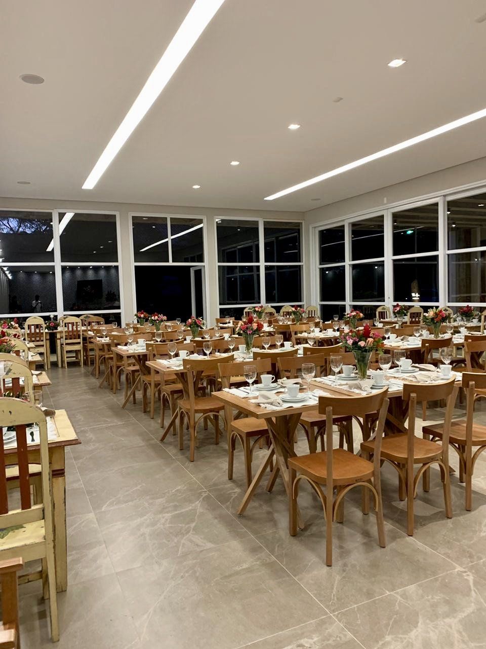 Uma grande sala de jantar cheia de mesas e cadeiras.