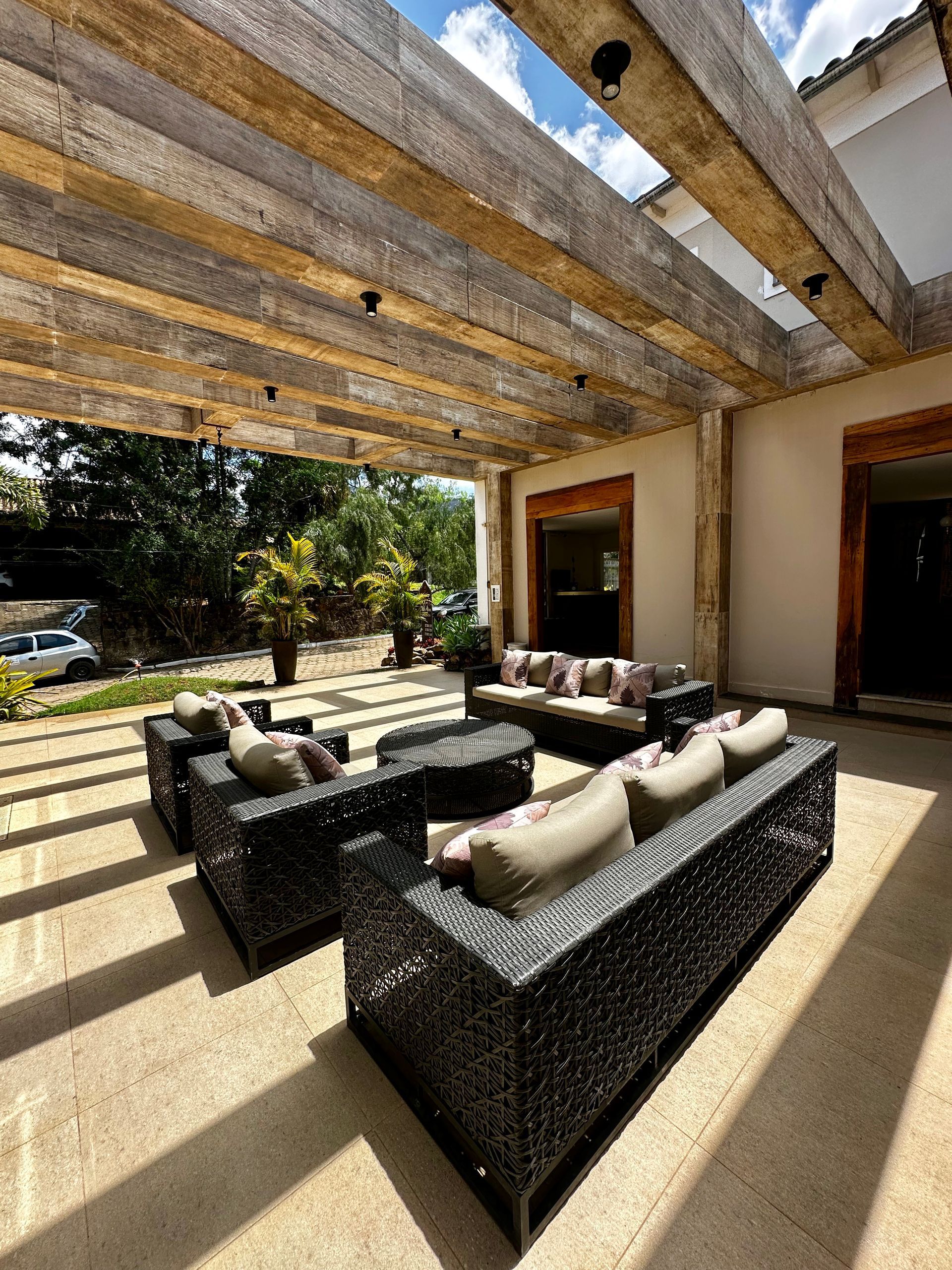 Um pátio com muitos móveis sob uma pérgola