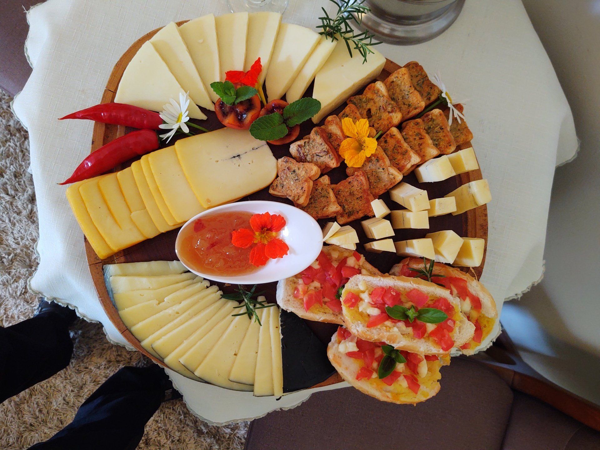Uma bandeja de madeira cheia de diferentes tipos de queijo e pão