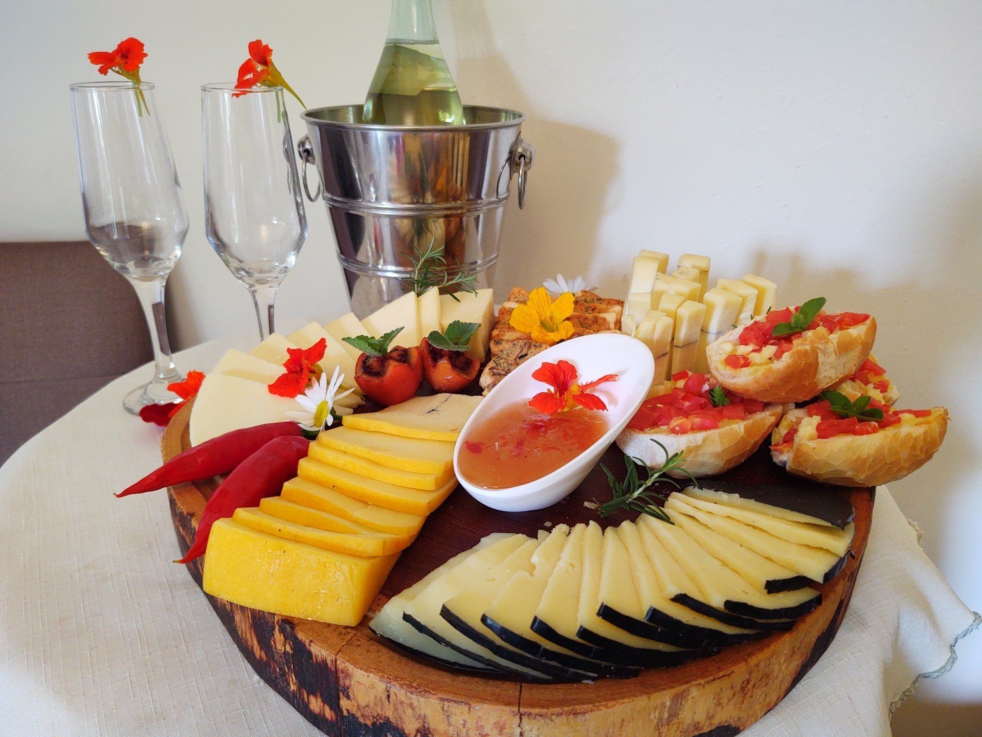 Uma tábua de corte de madeira com fatias de queijo e pão sobre ela