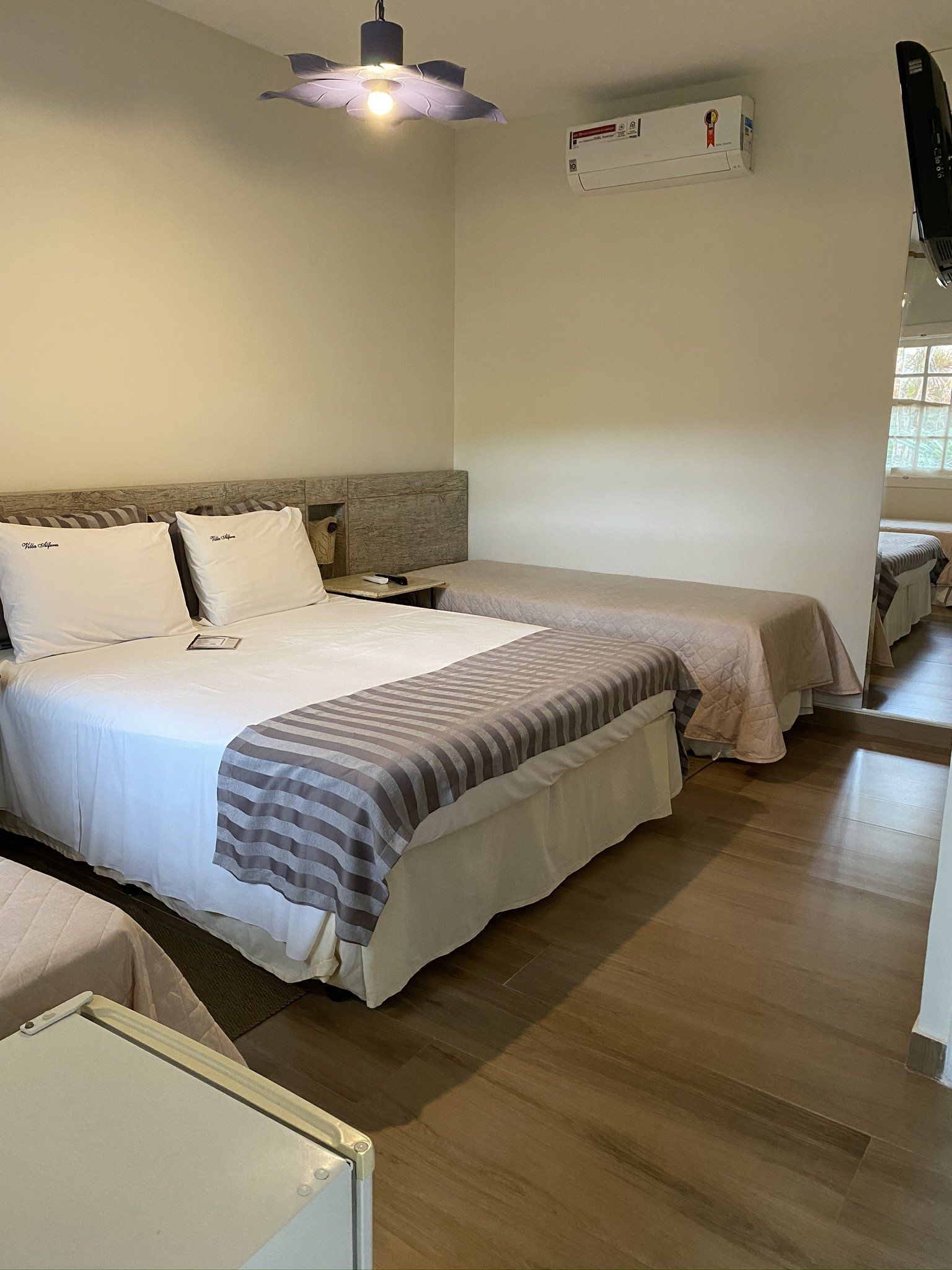 Um quarto de hotel com duas camas e uma geladeira.