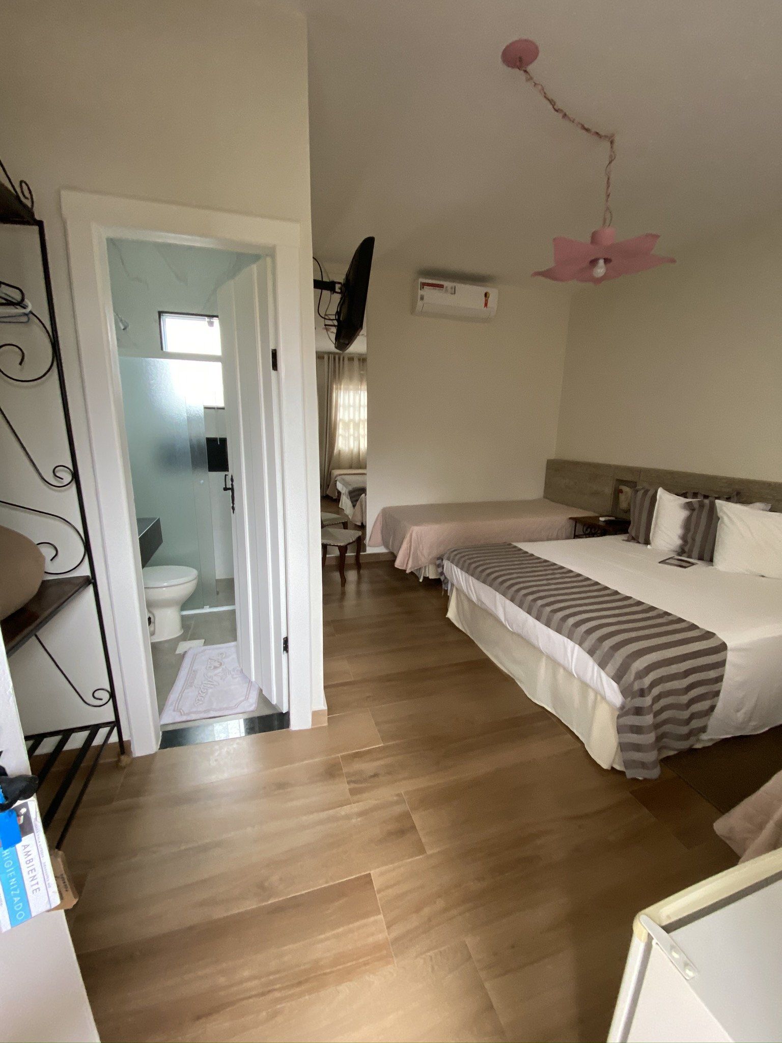 Um quarto de hotel com duas camas e um banheiro.