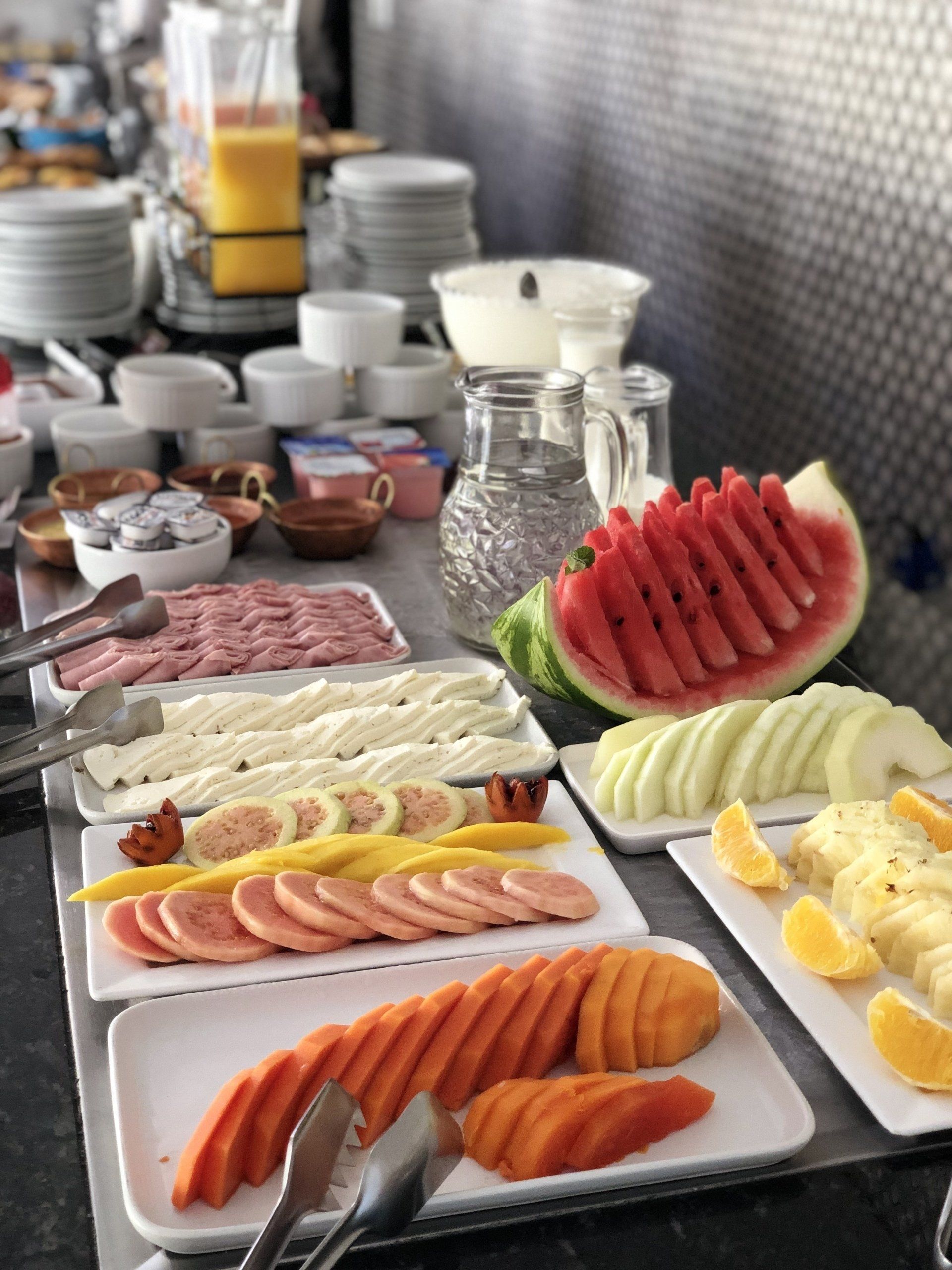 Uma mesa de bufê com uma variedade de frutas e carnes