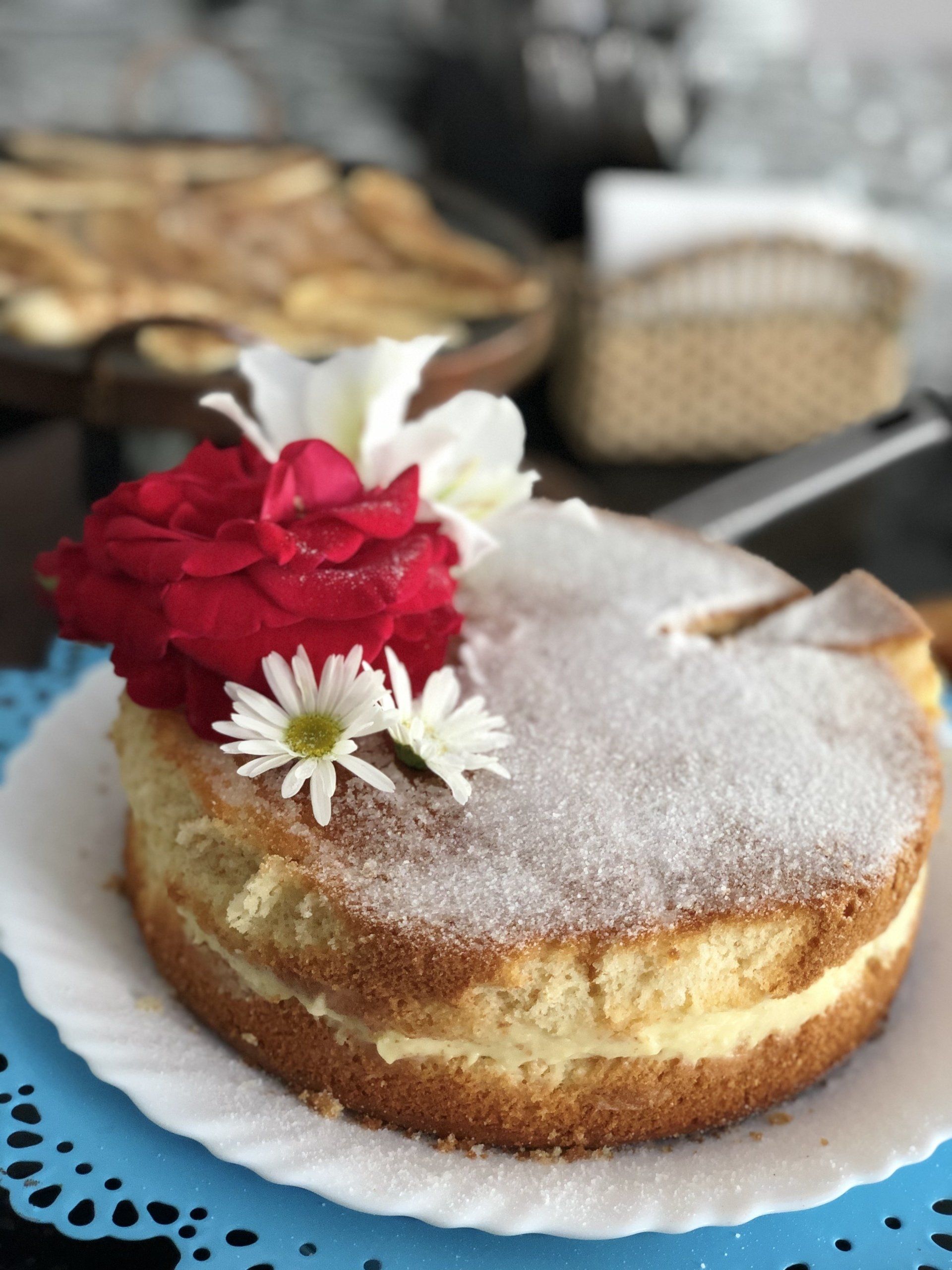 Um bolo com açúcar de confeiteiro e flores no topo