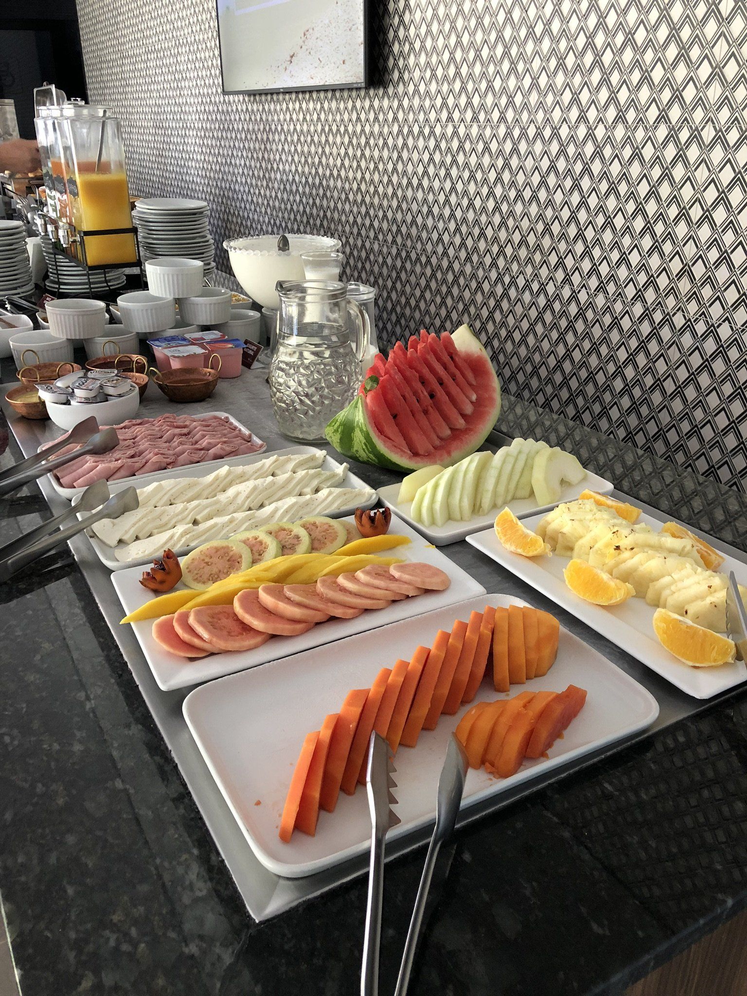 Uma mesa de bufê com pratos de frutas e vegetais.