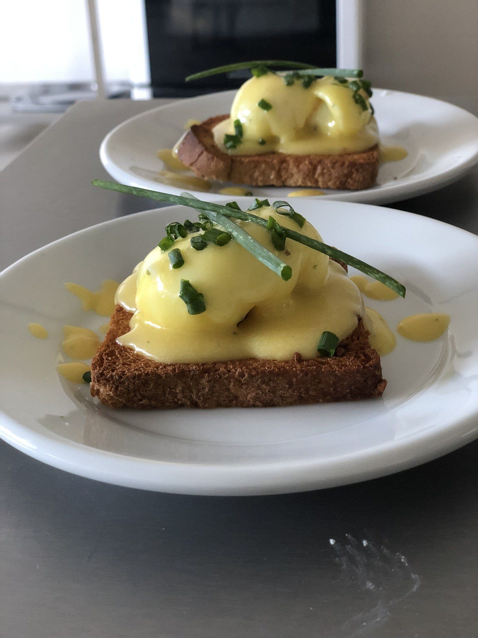 Dois pratos de comida com ovos e torradas sobre uma mesa.