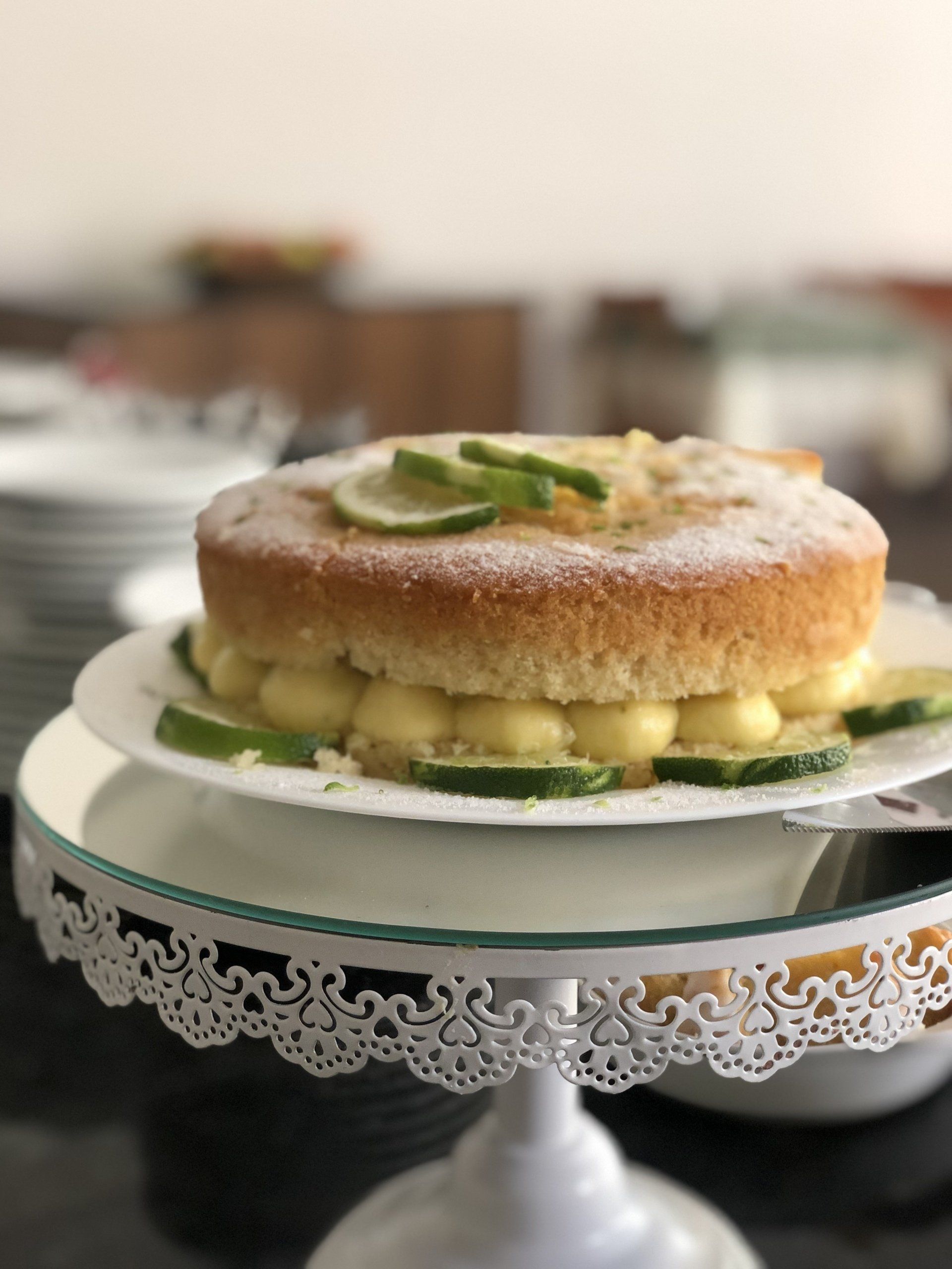 Um bolo em um suporte para bolos com fatias de limão no topo