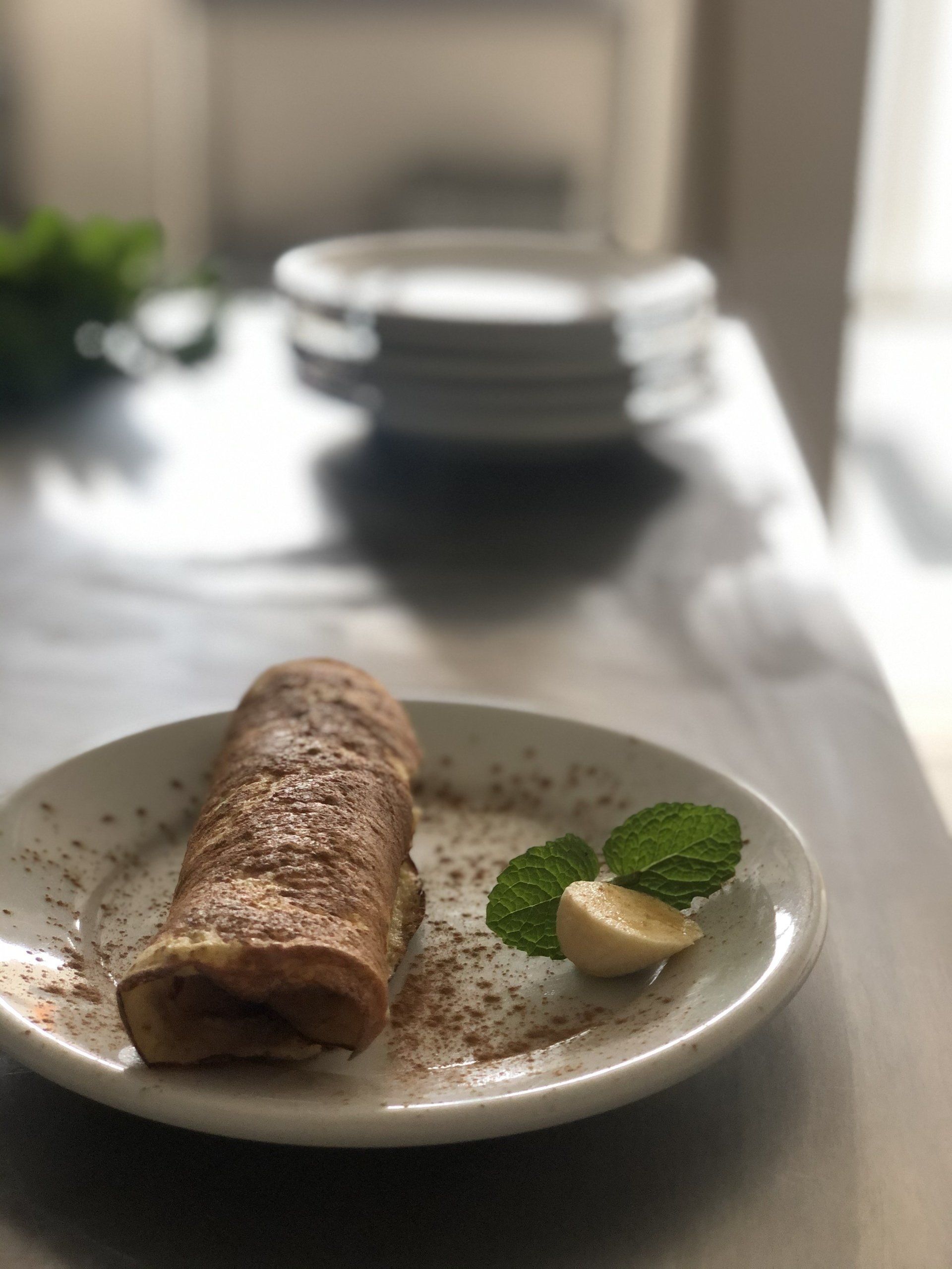 Um prato de comida com uma banana e folhas de hortelã