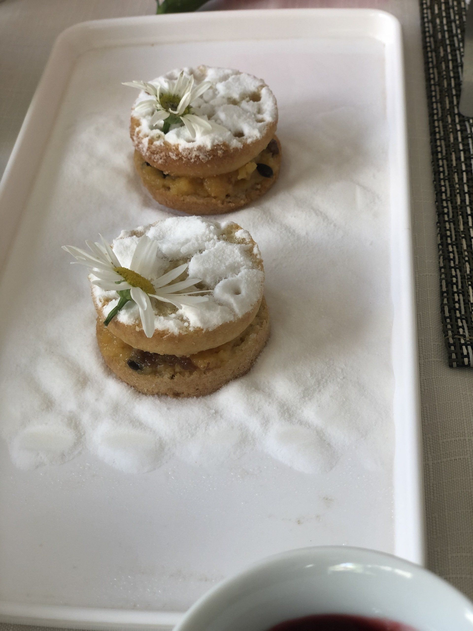 Uma bandeja de comida com uma taça de vinho ao fundo