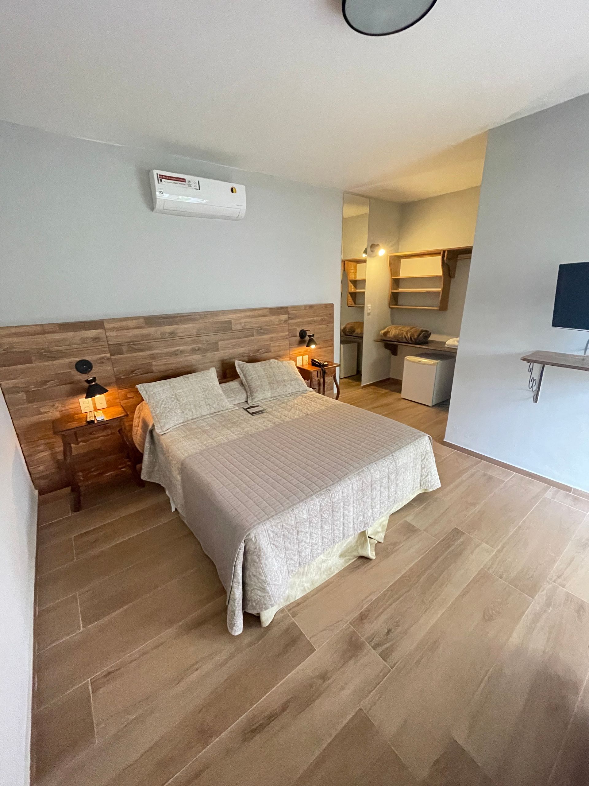 Há uma cama grande no meio do quarto.