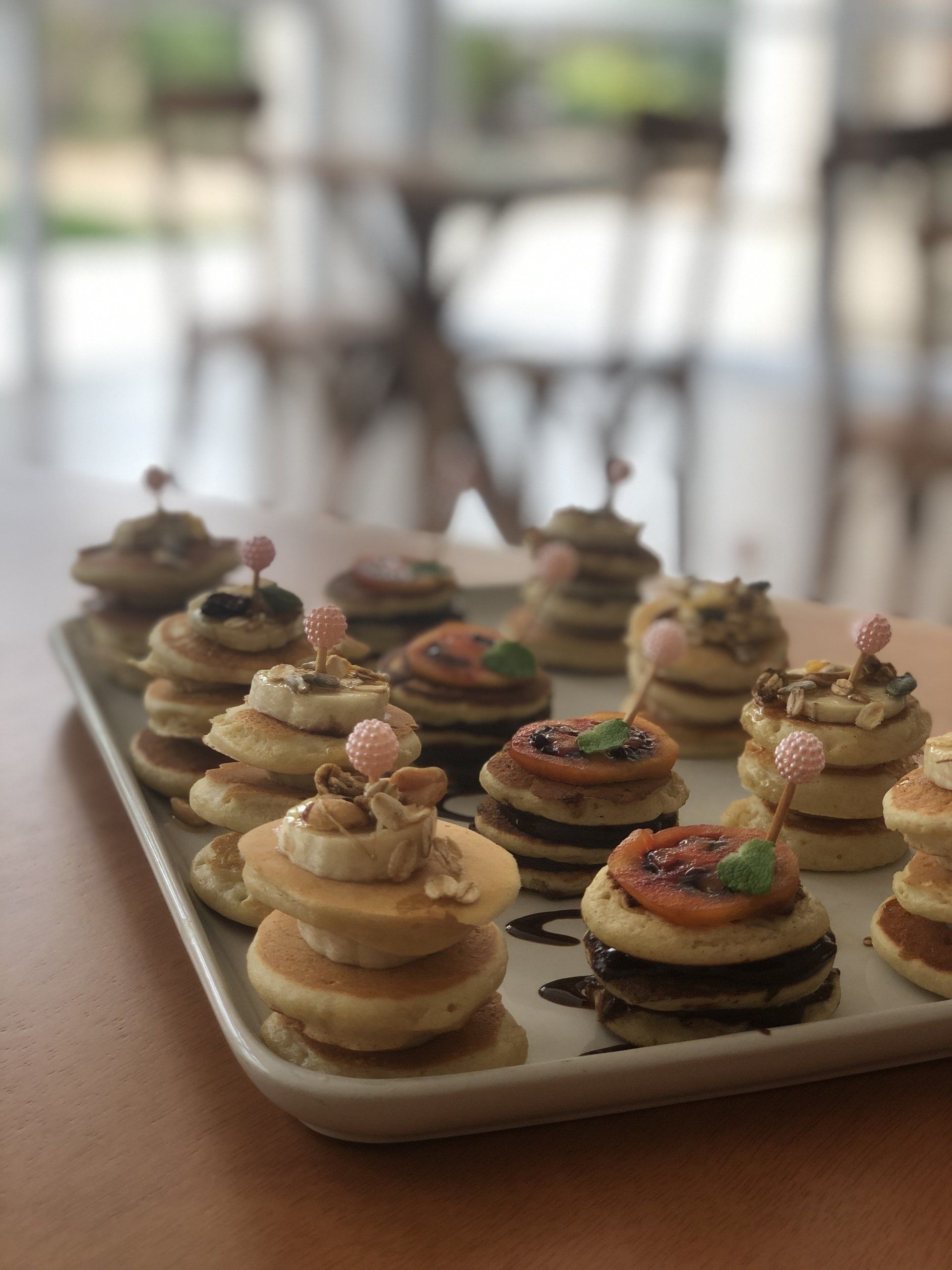 Uma bandeja de panquecas empilhadas umas sobre as outras sobre uma mesa.