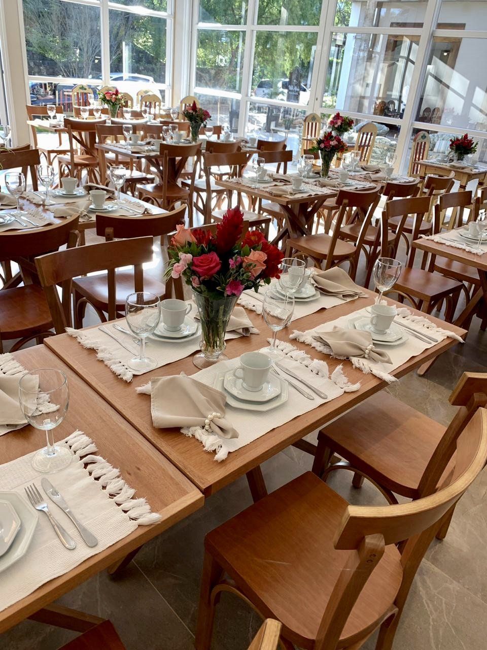 Um restaurante com mesas e cadeiras preparadas para uma refeição