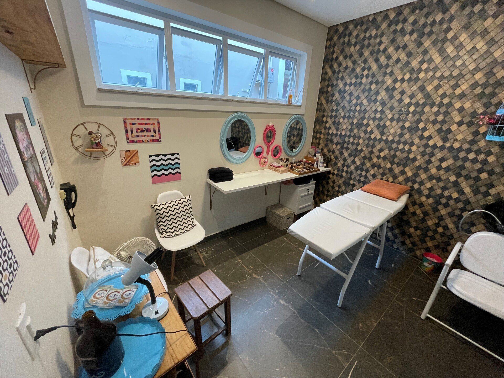 Um quarto com uma cama, cadeiras, espelhos e uma janela.