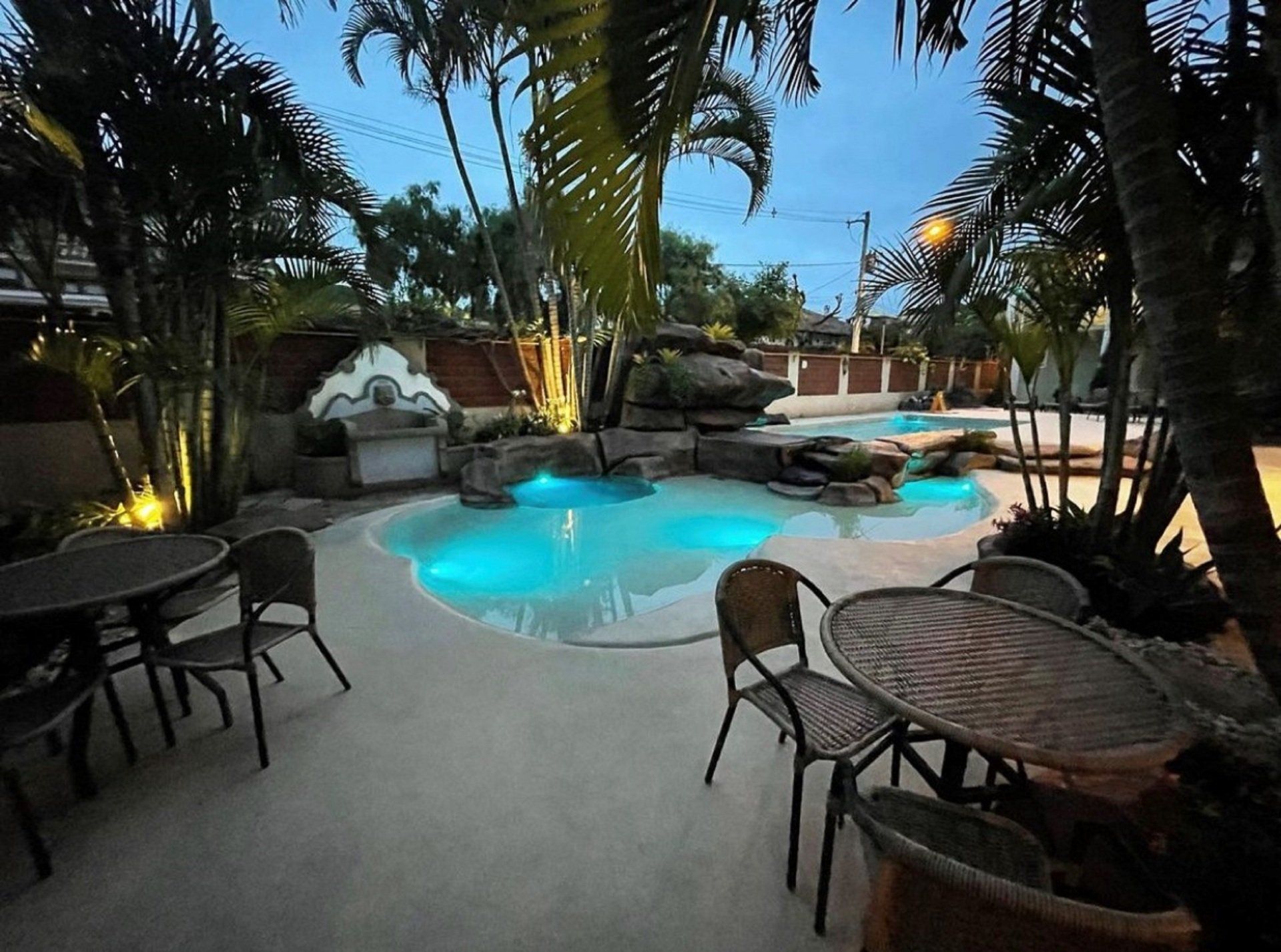 Uma grande piscina com mesas e cadeiras ao redor