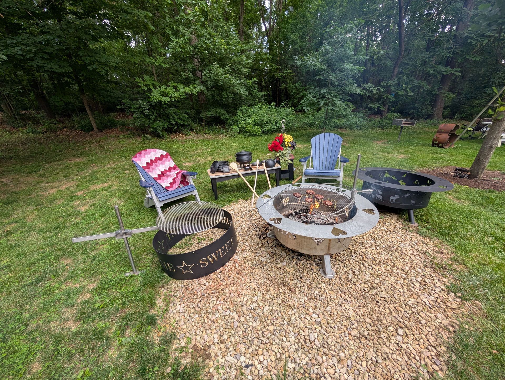 A fire pit is sitting in the middle of a lush green yard.
