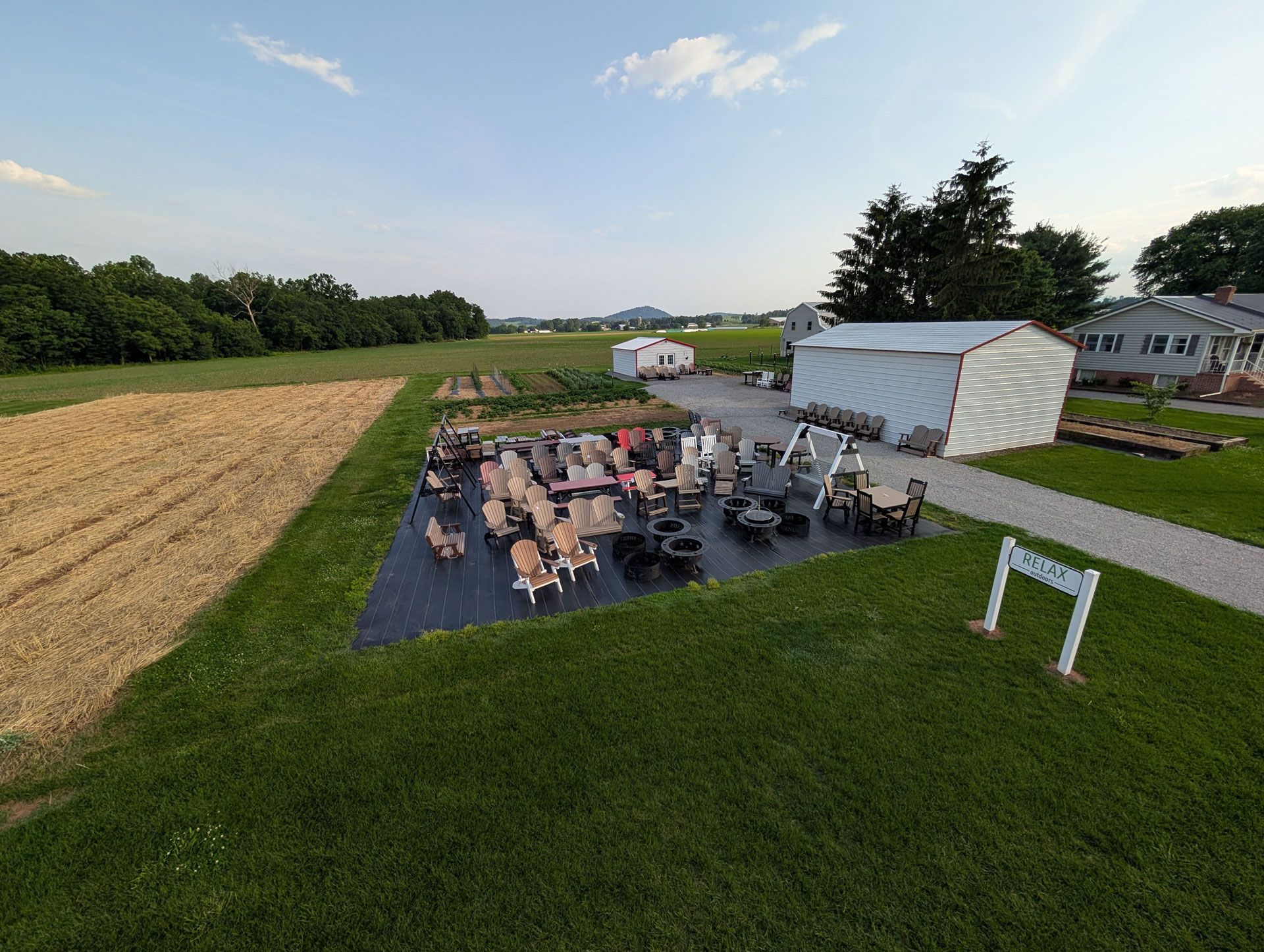 An aerial view of a group of people sitting around a fire pit in a field.