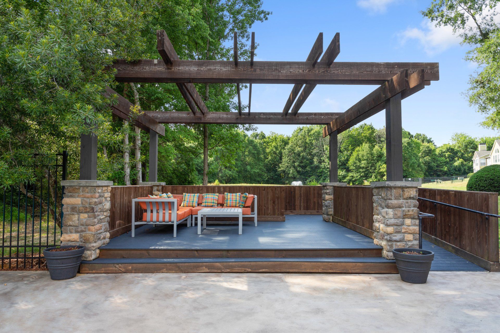 There is a pergola with a couch and a table underneath it Park at Oak Ridge.