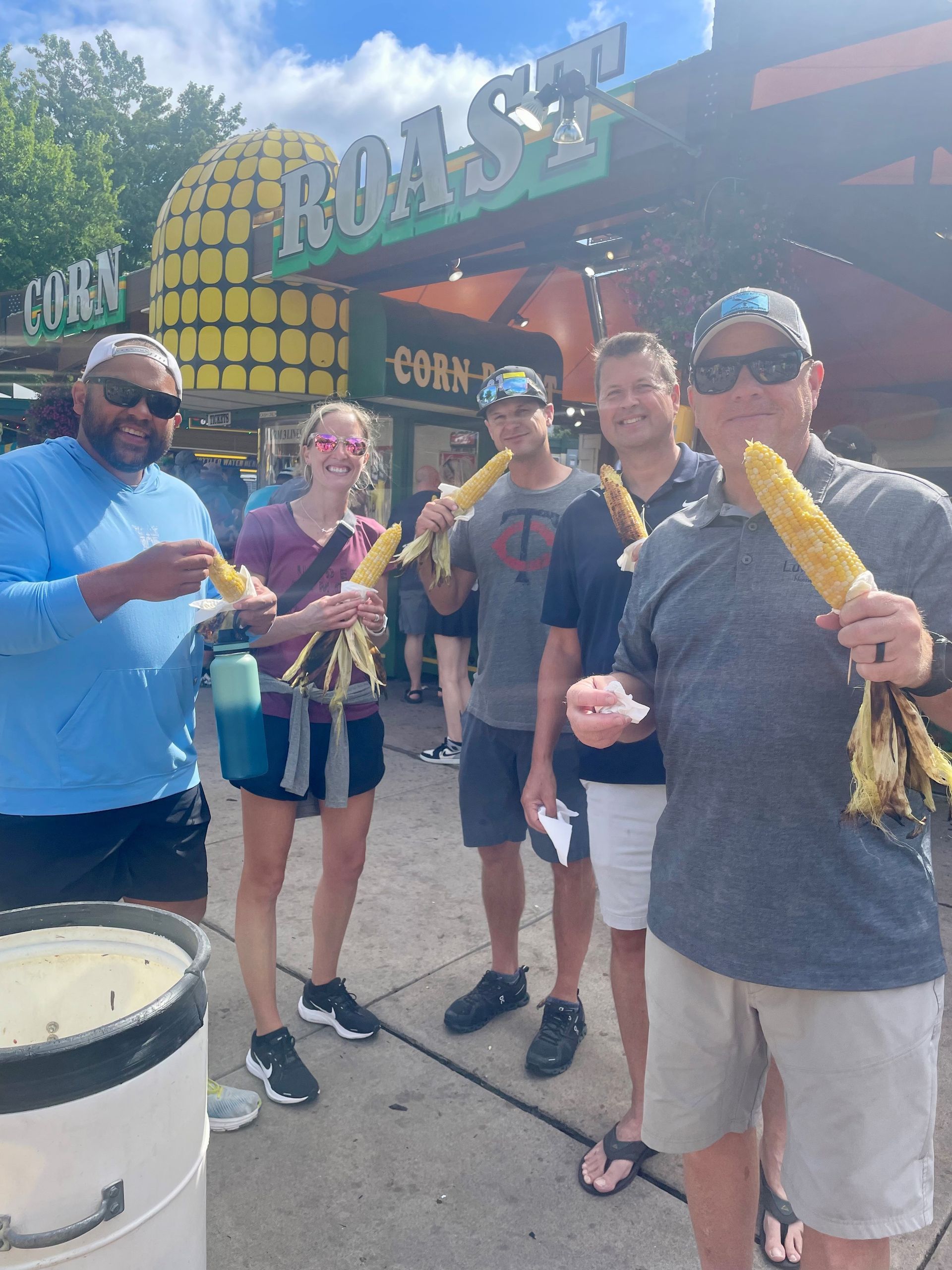 A large group of people are posing for a picture under a tree.