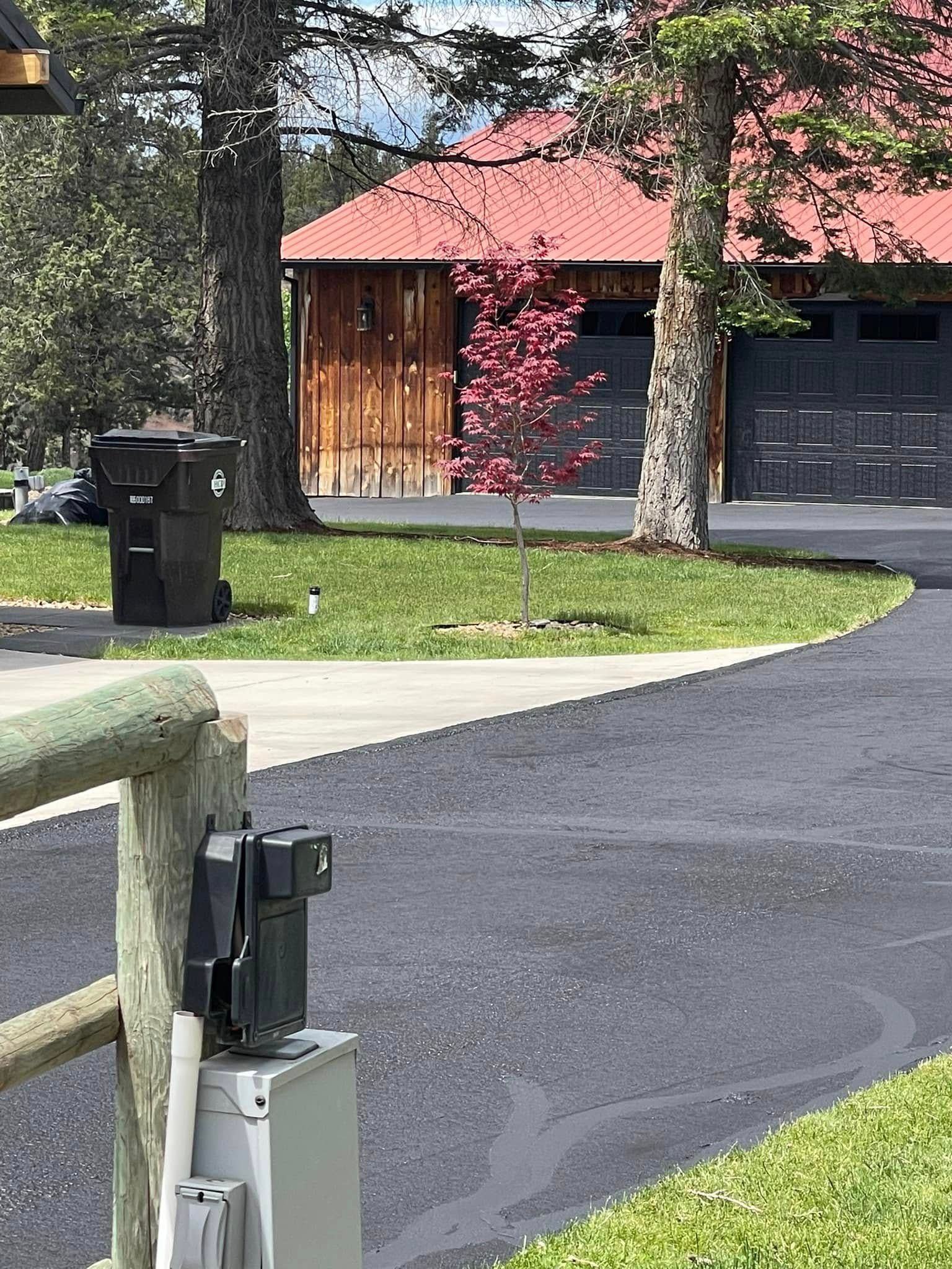 A driveway leading to a house with a red roof.