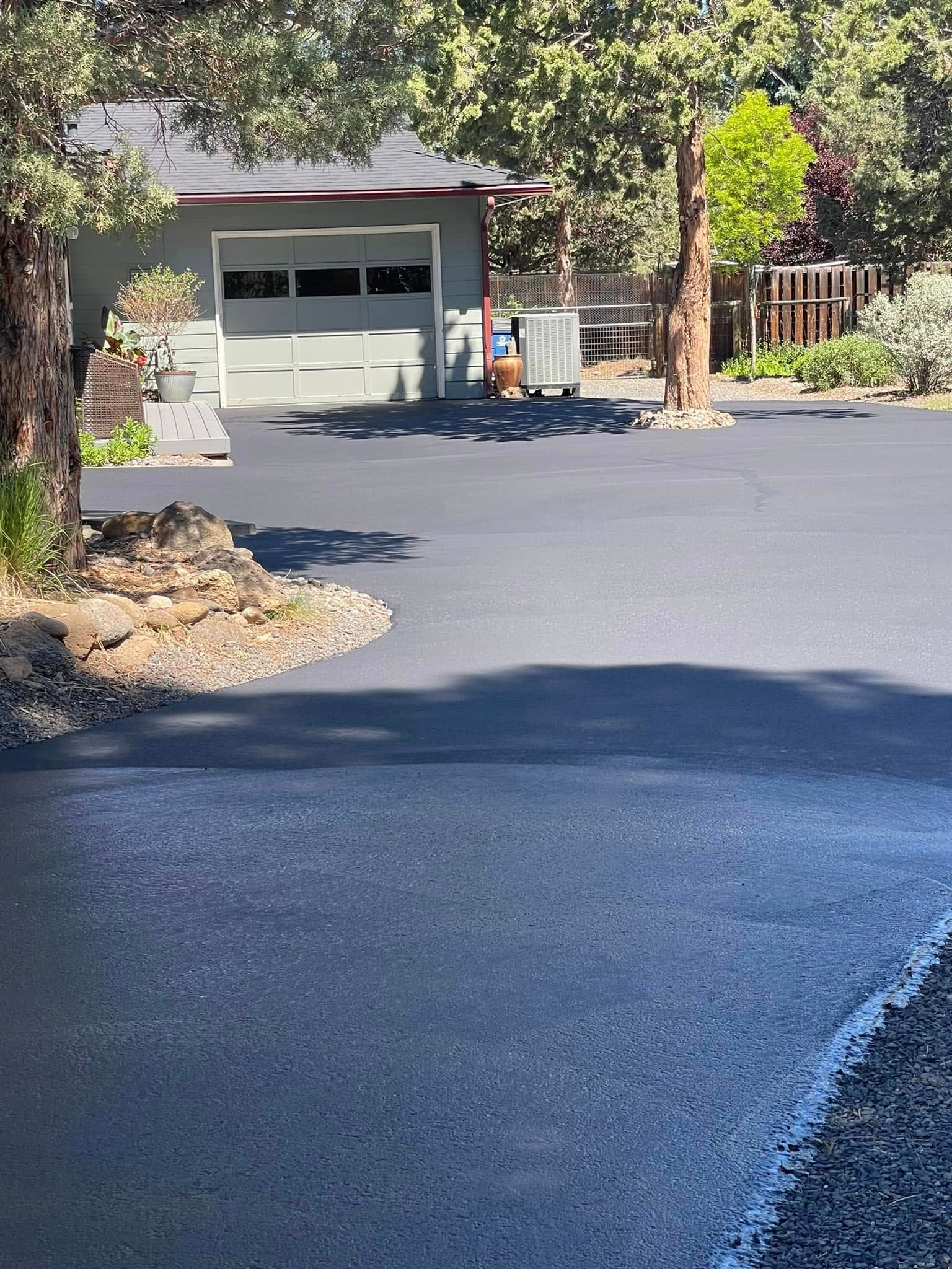 A driveway with a garage and a house in the background.