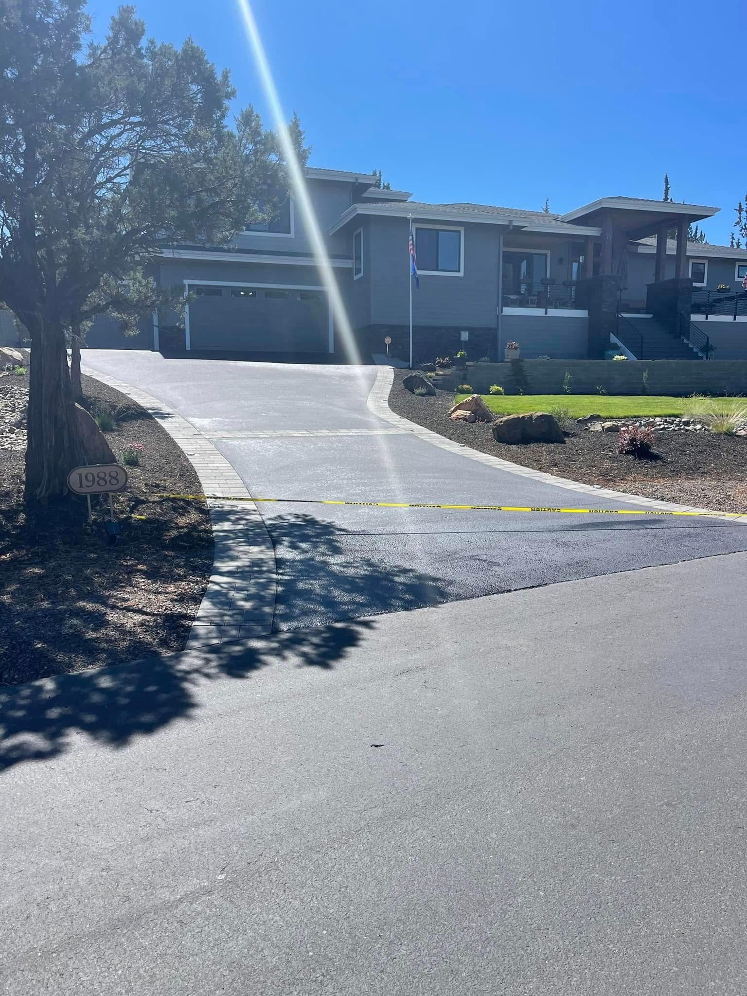 A house with a driveway and a tree in front of it