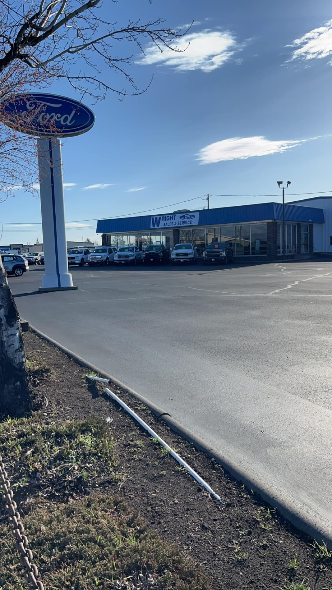 A ford dealership with a lot of cars parked in front of it.