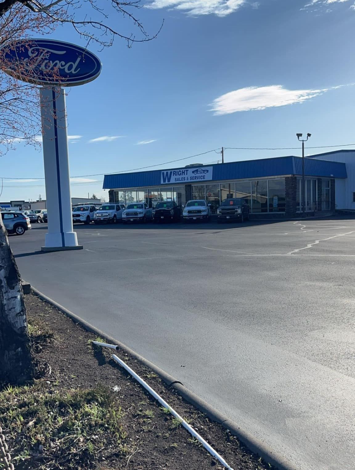 A ford dealership with a lot of cars parked in front of it.