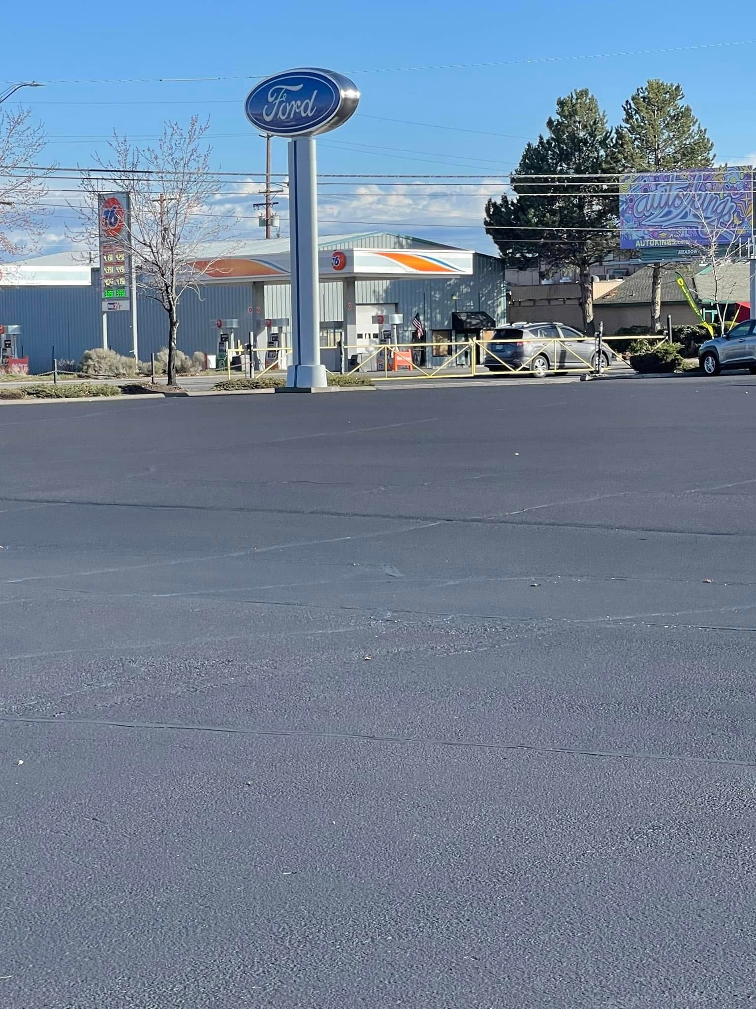 A parking lot with cars parked in front of a gas station.