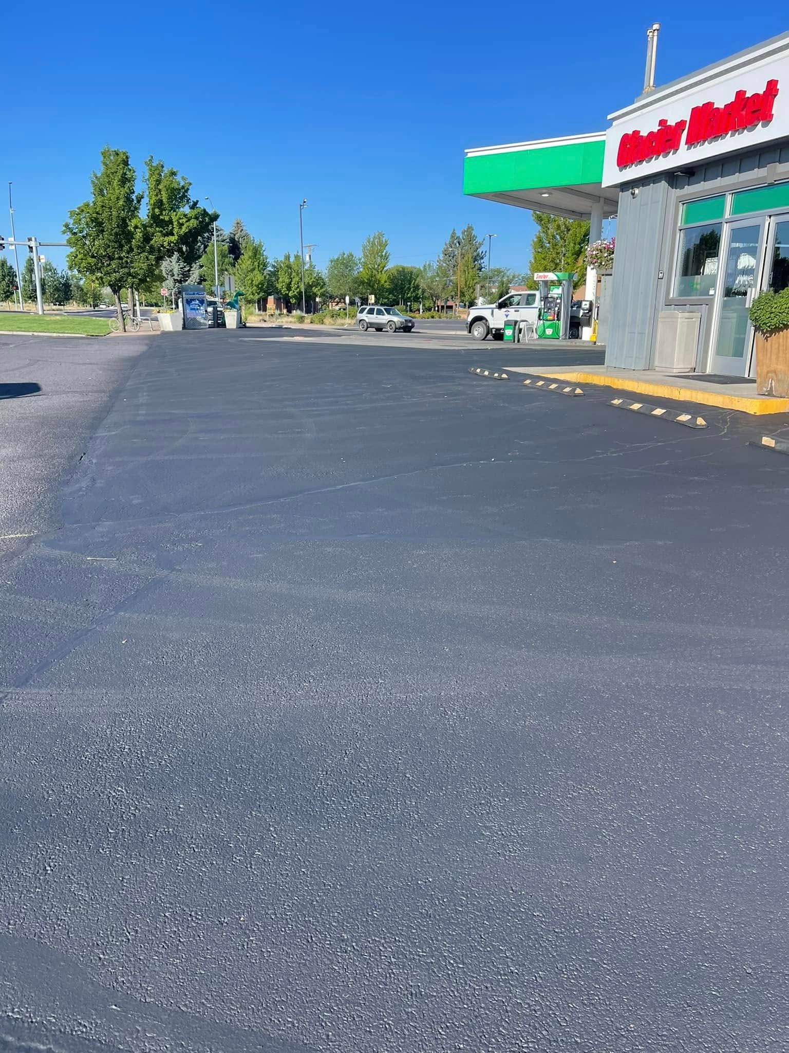 A parking lot with a gas station in the background