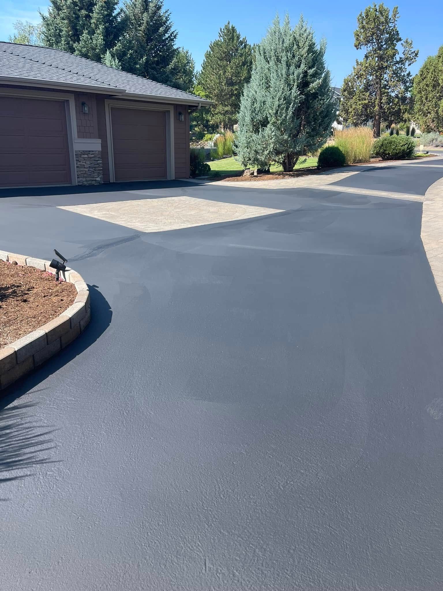 A driveway with a house in the background and trees in the background.