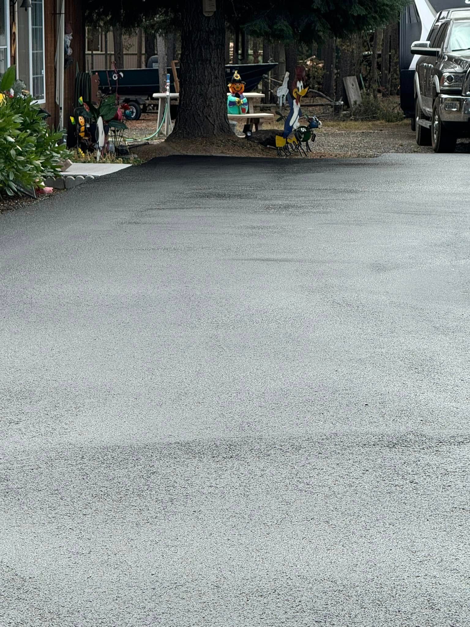 A row of cars are parked in a driveway next to a house.