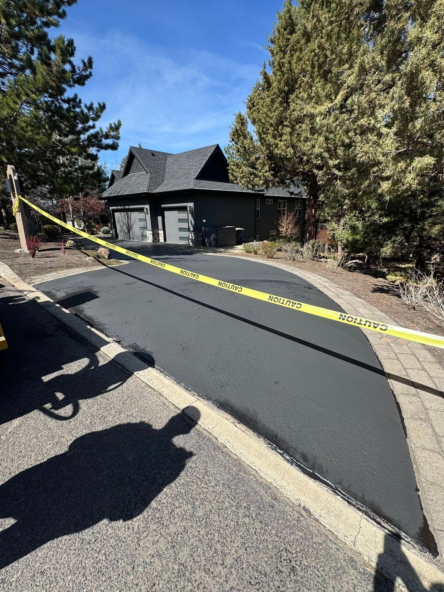 A house is sitting on the side of a road surrounded by trees.