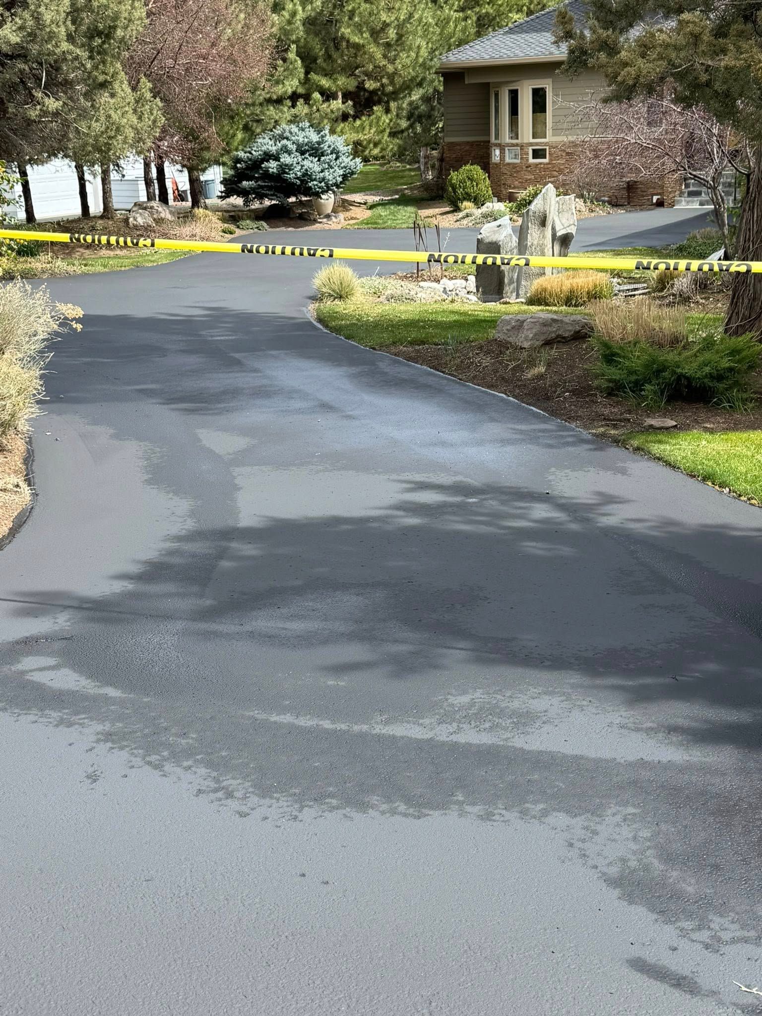 A driveway leading to a house with a yellow tape covering it.