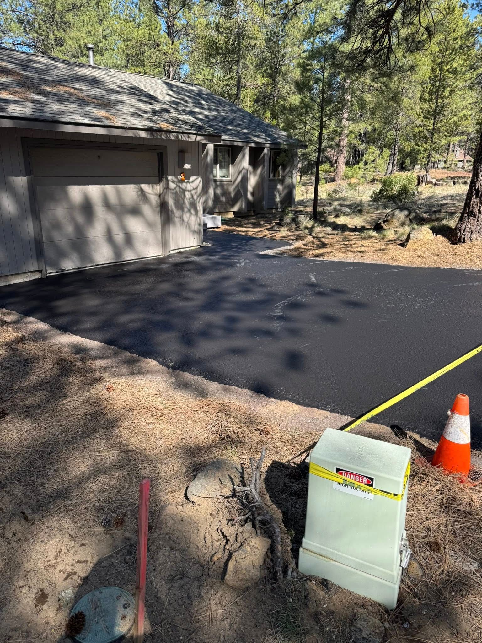 A house is being built in the woods with a new driveway.