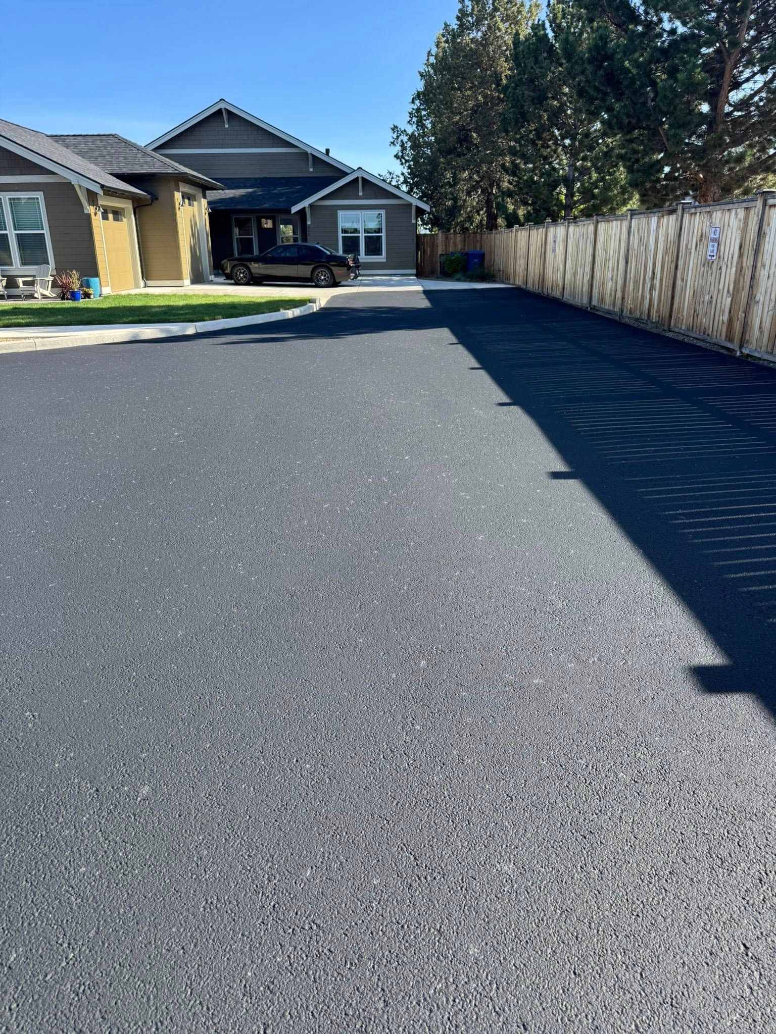 A driveway leading to a house with a car parked in front of it.