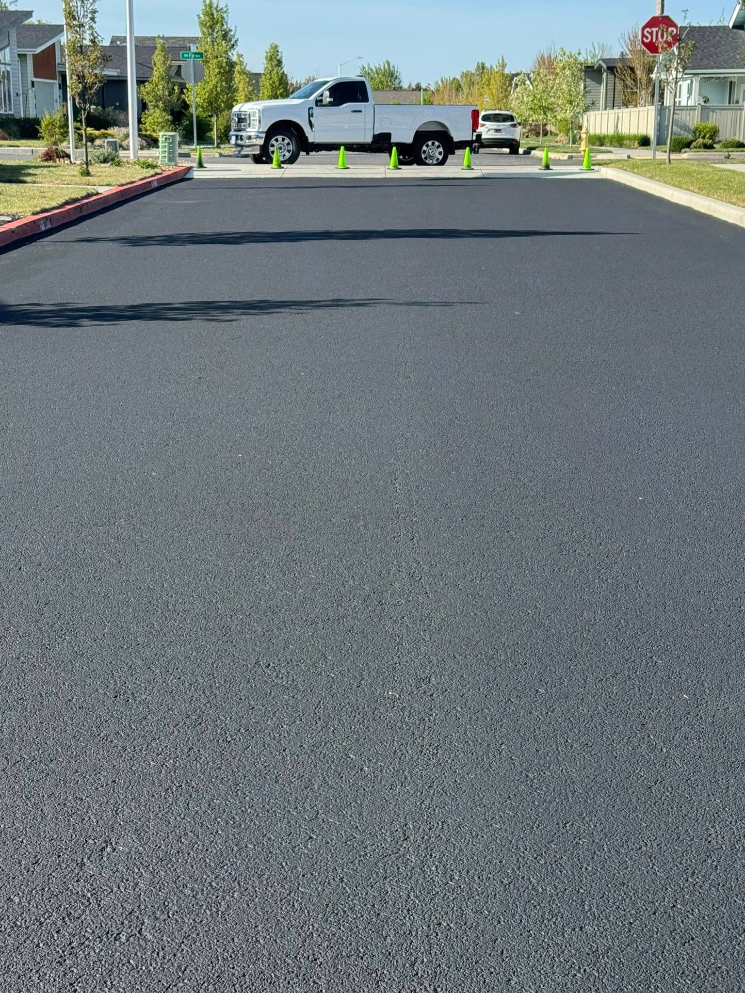 A truck is parked on the side of the road next to a stop sign.