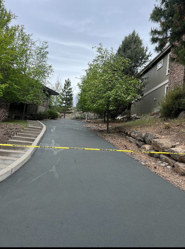 A road with a yellow tape along the side of it and a building in the background.