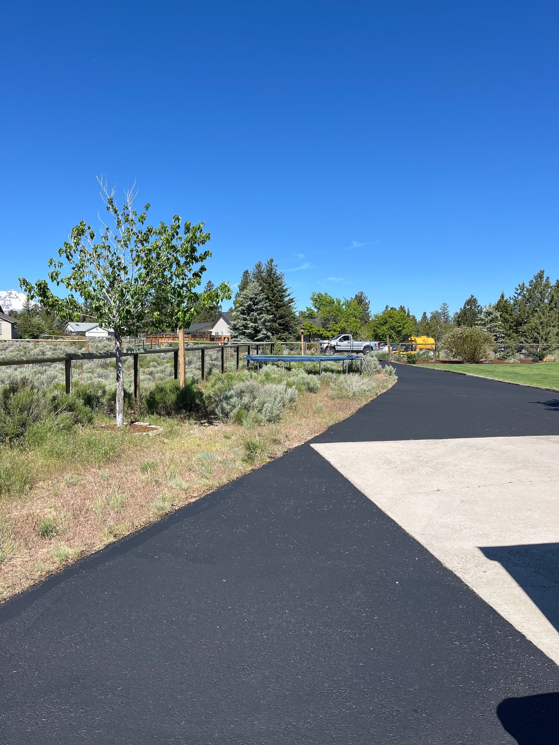 A road with a fence and trees on the side of it
